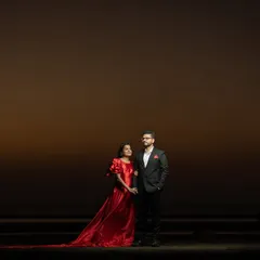 A minimalist yet powerful wide shot against the evening sky. The dramatic use of negative space creates a cinematic and epic feel, focusing entirely on the couple.