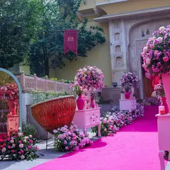 The welcome aisle was a vision in pink. We lined the path with oversized floral arrangements in modern vases, antique-style drawers, and a custom mirror sign to greet guests with elegance and charm.