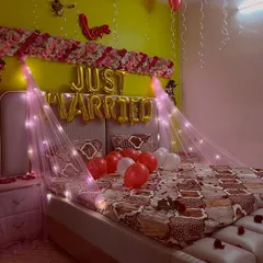 A close-up of the bed decoration, with red and white balloons and a 'Love' foil balloon accent.