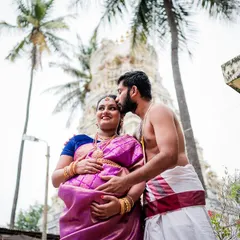 A tender moment with the husband-to-be kissing his wife's forehead during their outdoor maternity shoot, with a temple in the background.