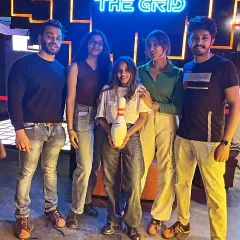 A group of friends posing with a bowling pin. Not sure what's more impressive, their scores or their poses.
