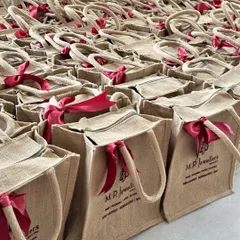 For our client M.P. Jewellers, we created hundreds of custom-branded jute bags for their Diwali gifting, each finished with a festive red ribbon.