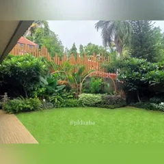 A beautiful lawn in a Juhu residence, framed by a sculptural fence and layered tropical planting. This space serves as a green heart for the property, providing a soft, open area for relaxation and play.