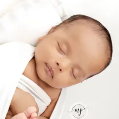 A close-up on the baby's face, highlighting their perfect, tiny features against the clean white background.