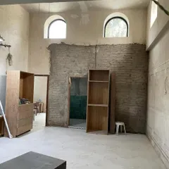 This is a space in transition. The original mitti walls are exposed, and the arched windows hint at the building's heritage. Empty shelves wait to be filled with stories. This is the quiet potential I look for in every project.