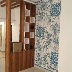 A custom mandala stencil design can beautifully complement your home's interior elements. Here, a blue and white pattern creates a striking accent wall next to a wooden partition, adding a touch of traditional art.