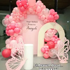 A modern and chic butterfly theme using shades of pink for a "Princess" birthday. The setup features two arched backdrops, a dense balloon garland, and minimalist laser-cut butterfly props.