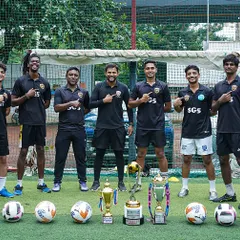 Our coaches pointing to the SG5 crest. We are one team, united in our mission to build champions.