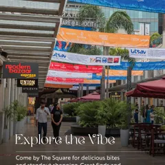"Explore the Vibe." A candid shot of The Square, with event banners overhead, inviting people to enjoy the delicious bites and standout shopping that we offer.