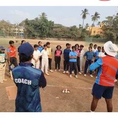 A coach providing guidance to a group of talented girls during the selection process. We aim to build a strong foundation for women's cricket.