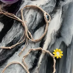 Both the evil eye and daisy bracelets, showing how they can be worn together or gifted as a pair.