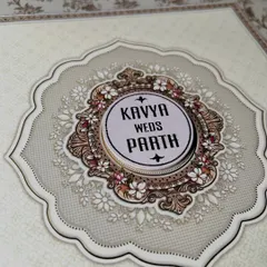 An intricate floral emblem designed to frame the couple's names. This style of custom logo adds a layer of sophistication and personalization to any wedding invitation.
