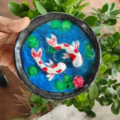 A beautifully detailed koi pond dish made from clay. This is a great example of the intricate and personalized pieces you can create in our hand-building pottery sessions.