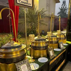 Our vegetarian counter setup, featuring ornate golden chafing dishes on a lush green turf base. We believe the presentation of the food should be as exquisite as its taste.