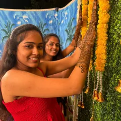 Happy clients posing with their intricate henna at a festive event.