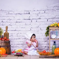 Welcome to the little chef's kitchen! This studio theme is complete with a chef's hat, apron, and a variety of colorful fruits and vegetables for a fun and interactive photoshoot.