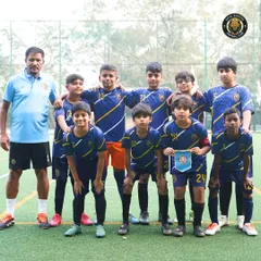 The U-13 team stands united with their coach before a match at The Winter Cup in Mumbai. Posing for a team photo is part of the pre-game ritual that builds unity and focus.