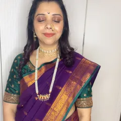 My client Anita celebrating Gauri Ganpati. I created this classic look with a pearl choker, a traditional nath, and makeup that complements her beautiful purple Paithani saree.