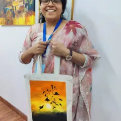 A doctor from our AIIMS workshop with her beautifully painted tote bag, featuring a serene sunset. A perfect creative outlet after a long week.