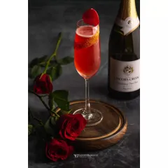 A romantic red wine cocktail garnished with a rose petal, shot for Whiskey Amour. The composition with fresh roses adds to the story, making it perfect for a Valentine's or special occasion menu.