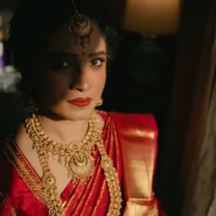 I love creating dramatic and soulful portraits. For this South Indian bridal look, the interplay of light and shadow highlights the rich temple jewellery and the deep red of her Kanjivaram saree. The makeup remains elegant and defined, proving that bold tradition can be achieved with a minimal touch.