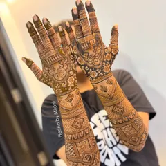 A classic full-coverage bridal mehendi that extends up the forearms. This design uses a mix of geometric patterns, floral motifs, and bold, filled sections to create a rich and satisfying look for the bride's special day.