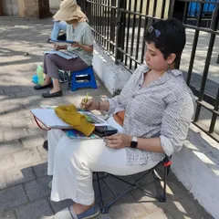 Another shot of me focused on my sketchbook during an outdoor session near Metro Cinema. These sketch walks are where I practice my craft of drawing people and places from life.