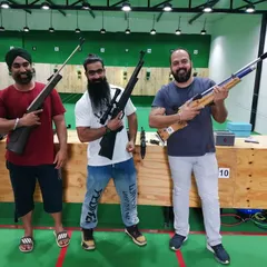 A group of friends posing with their chosen air rifles after a competitive and fun shooting session. Everyone gets to pick a rifle that feels right for them.