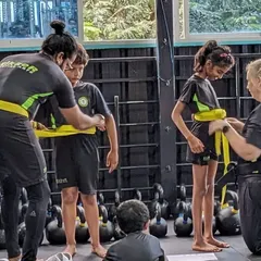 The belt tying ceremony is a significant moment in a martial artist's journey. Here, I am awarding new yellow belts to students who demonstrated excellent technique and focus during their grading.