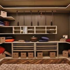 This contemporary walk-in wardrobe showcases a sophisticated material combination. The matte lacquer finish provides a neutral backdrop, while drawers clad in deep blue leather add a touch of bespoke luxury and personality to the space.