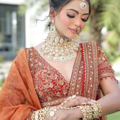 It's all in the details. This close-up showcases a stunning bridal jewelry set with Kundan-style work and delicate emerald green accents. We help you find the perfect rental jewelry, including the nath and maang tikka, to complete your look.
