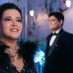 A beautiful shot focusing on the bride's radiant expression, with her groom admiring her in the background. This storytelling technique adds a layer of emotion to modern portraits.