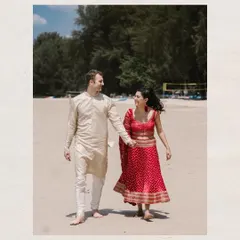 A walk to remember. An Indian bride and a groom in western attire walk hand-in-hand on the sandy shores of Thailand, a beautiful symbol of two cultures uniting.