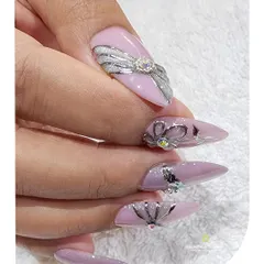 This side view highlights the profile of the stiletto nails and the raised 3D bow and floral designs, showing the intricate sculpting work involved.