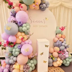 A beautiful "Baby in Bloom" setup for Sonam's baby shower, featuring a pastel balloon arch with butterflies and fresh floral accents.
