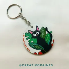 A close-up of a Jiji keychain, inspired by Studio Ghibli's "Kiki's Delivery Service." I love capturing the personality of beloved characters like this little black cat among the leaves.
