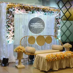 This elegant stage setup is perfect for engagements or intimate receptions. The rental includes a modern gold-finish sofa, a backdrop of sheer white curtains with fairy lights, and a beautiful floral border.
