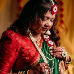 A serene portrait of the mom-to-be, looking down with a gentle smile. Her soft glam makeup highlights her radiant skin.