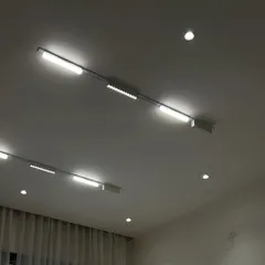 A close-up of a white magnetic track light system with multiple fixtures, providing bright, directional light.