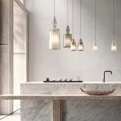 A linear arrangement of the Matteo Ugolini pendants over a minimalist stone counter. This shows how they can be used to create a simple, elegant rhythm in a space.