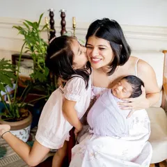 A kiss for mum from her biggest girl, while she cuddles her newest arrival. This photo beautifully captures the changing family dynamic, full of love and excitement. In-home lifestyle sessions are perfect for these natural, heartfelt interactions.
