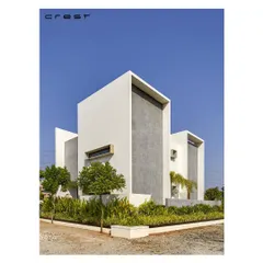 The 'Framed House' uses bold, intersecting white volumes to create deep-set openings and a powerful minimalist aesthetic. A textured grey panel adds a contrasting element.