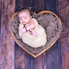 The pure innocence of a newborn is something we cherish. This simple, heartfelt pose in a heart-shaped basket is a timeless way to remember how small they once were.