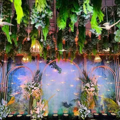 I brought a tropical rainforest to life for this Sangeet night. The decor features a lush canopy of hanging greenery, a hand-painted backdrop, and whimsical details like suspended birds to create an immersive, enchanting atmosphere.