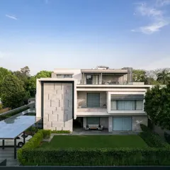 An elevated view of Residence 338, showing its relationship with the surrounding greenery. The design includes a rooftop terrace and large windows to maximize natural light and views.