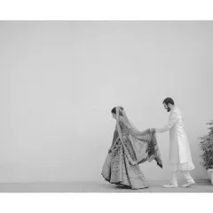A quiet, unnoticed moment where the groom holds his bride's dupatta so she can walk freely. Stripped of colour, this small gesture of care becomes a powerful statement about their companionship.