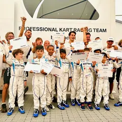 Our young drivers celebrating the completion of their summer camp at the world-renowned Baby Race Driver Academy in Italy, holding their certificates of participation.