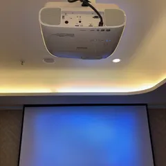 The Epson projector and motorized screen ready for a movie night. We ensure the projector is perfectly aligned with the screen for a sharp, cinematic image that fills the frame.