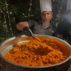 A close-up of the Mutton Nalli Barra, a rich and aromatic Mughlai delicacy, being slow-cooked in a traditional large pot to ensure tender meat and deep flavor.