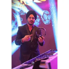 Our DJ is the backbone of our sound, mixing tracks seamlessly to keep the energy high all night. He's pointing at the decks, ready to drop the next banger.